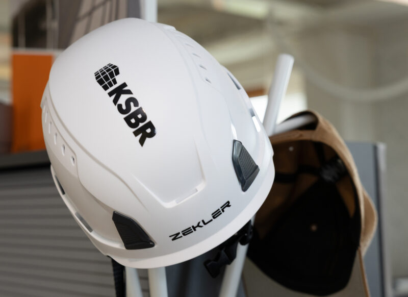 Valkoinen turvakypärä on pöydällä.