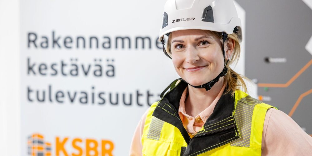 Turvavarusteisiin pukeutunut nainen seisoo.