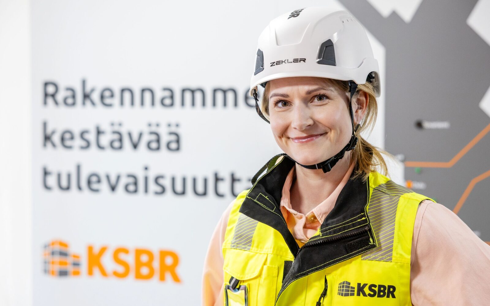 Turvavarusteisiin pukeutunut nainen seisoo.