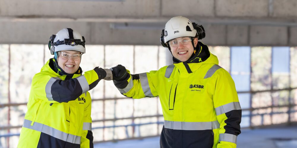 Kaksi rakennustyöntekijää onnittelee toisiaan.
