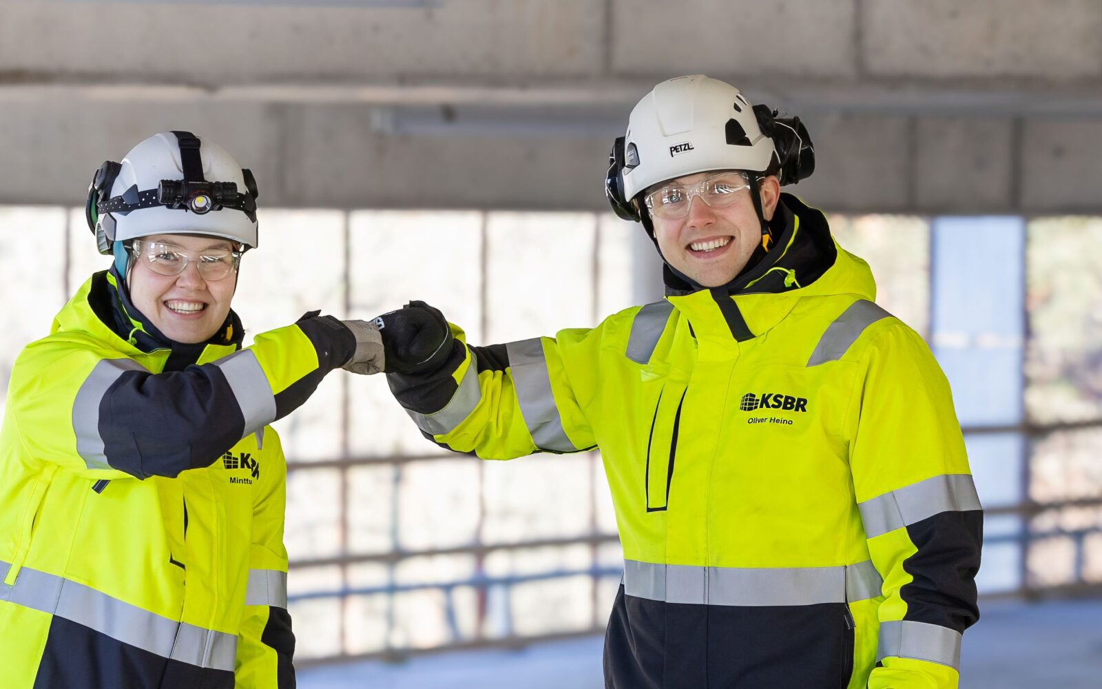 Kaksi rakennustyöntekijää onnittelee toisiaan.